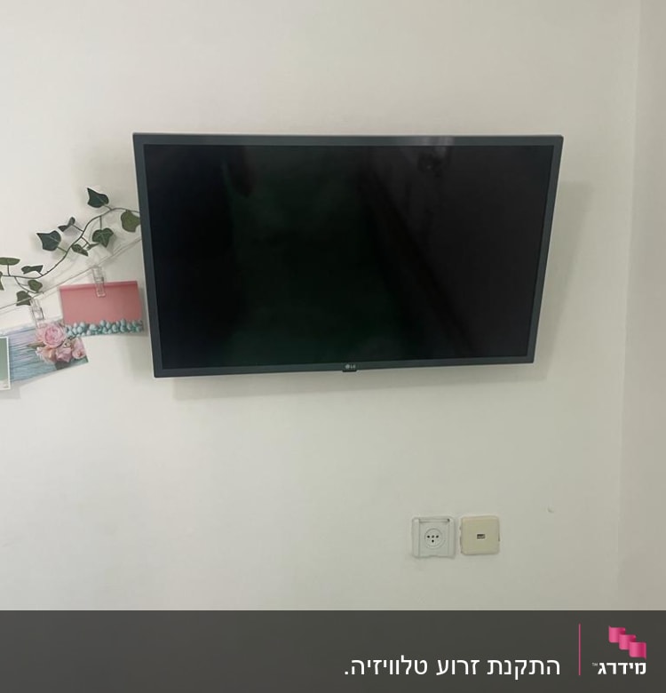 טלוויזיה תלויה על הקיר ליד שקע חשמל